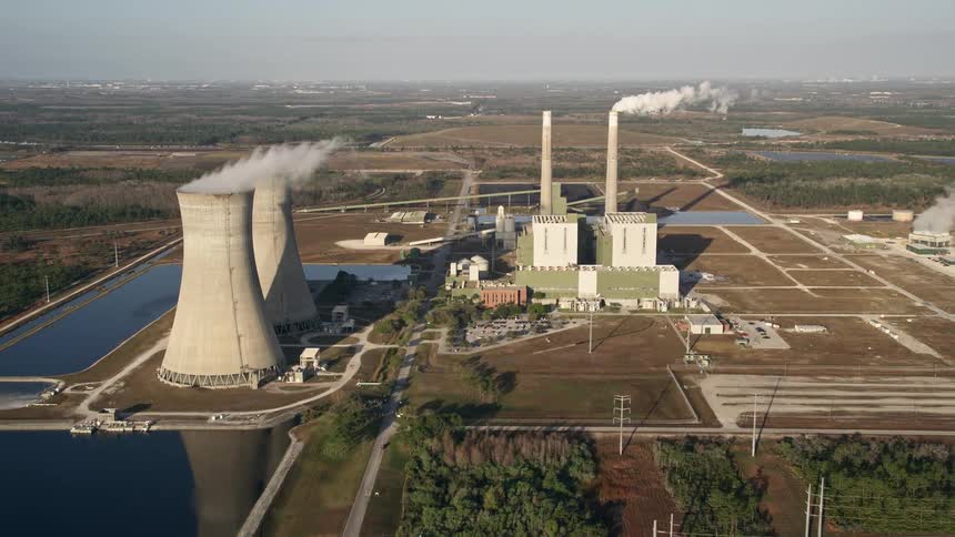 Aerial footage of Stanton Energy Center power plant in Orlando during sunrise showcasing its smoke stacks and industrial energy generation capabilities