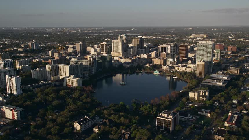 An aerial view at sunrise of downtown Orlando Florida with surrounding residential condos and a small lake