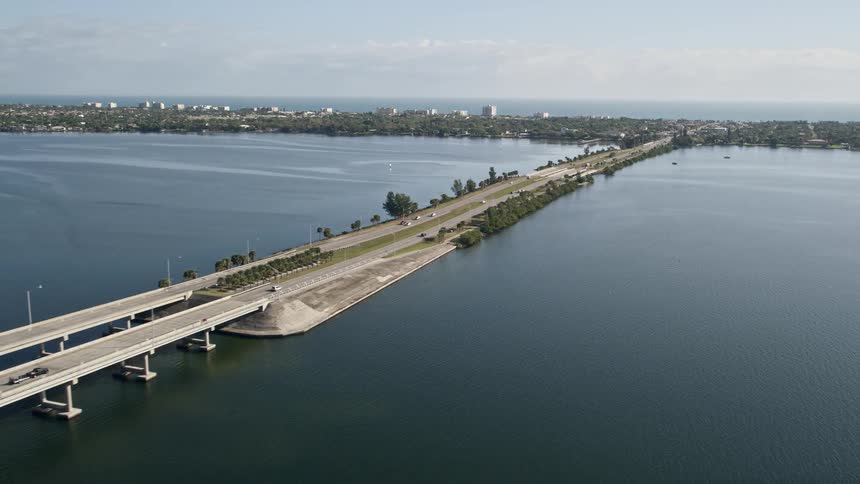 An aerial view of the Melbourne Causeway spanning the Indian River in Florida with light traffic passing through during the day