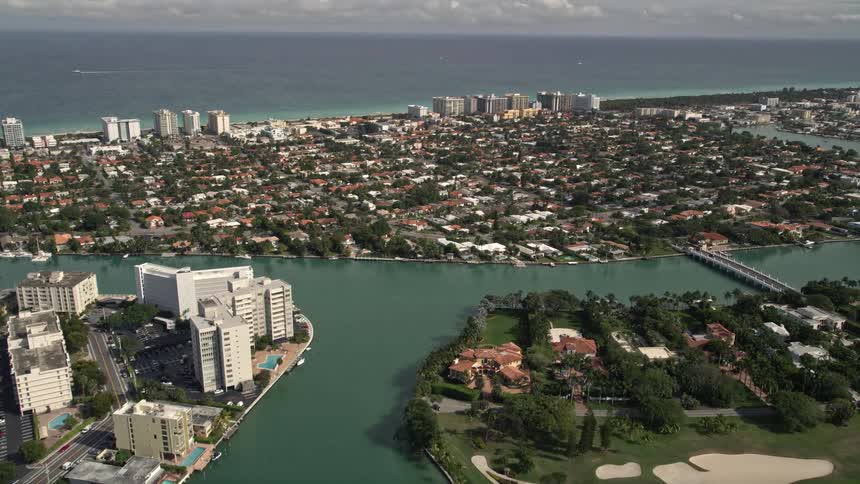 Approaching the coastal community of Surfside Florida by a 5K aerial view on a sunny day