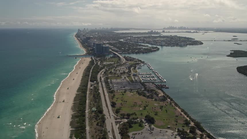Aerial footage captures the stunning Florida coastline as the camera tilts up to reveal more of Bal Harbour with clear skies and a mix of residential and recreational activities