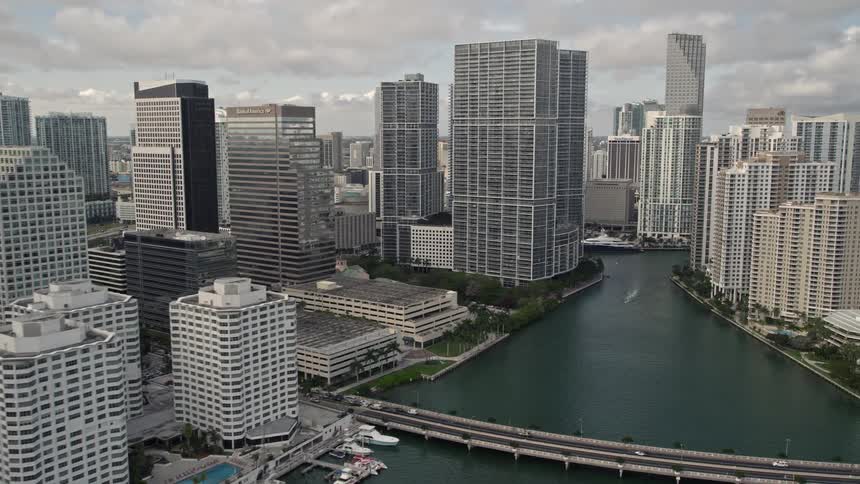 A breathtaking flyover of Downtown Miamis high-rise waterfront skyline revealing the Brickell Key Bridge