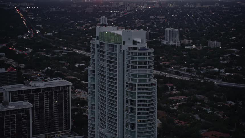 Approaching the Santa Maria high-rise condominium at sunset in Downtown Miami amidst cloudy skies and modern buildings