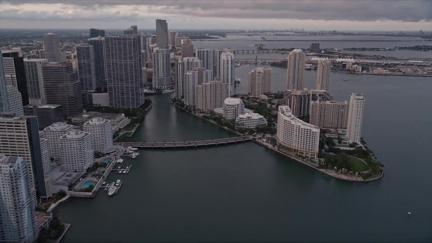 Approaching the Brickell Key bridge traffic and high-rise buildings are visible against the backdrop of a beautiful Florida sunset
