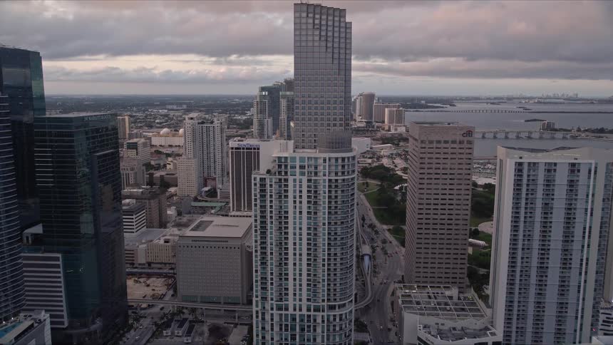 A stunning sunset drone view of the towering buildings and boats between Brickell Key and Icon Brickell in downtown Miami Florida