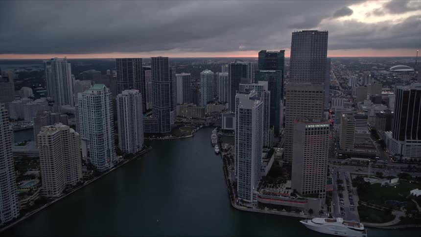 An aerial view of Miami River and downtown skyscrapers at sunset showcasing the high rises and stunning water body in Southern Florida