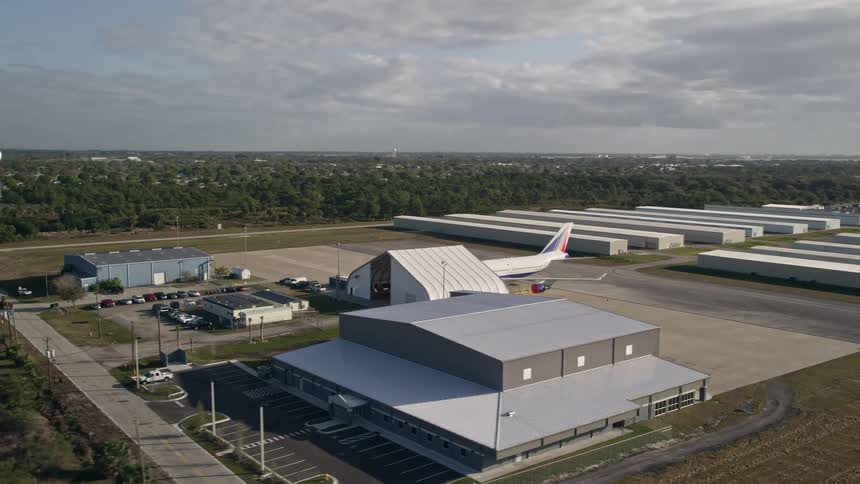 A stunning aerial view of a passenger jet among hangars at Melbourne International Airport during sunrise in Florida