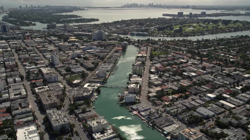 Aerial view of a waterfront property on a canal through Miami Beachs residential neighborhood