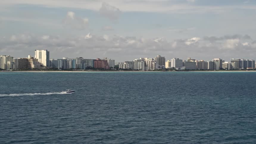 A fishing boat sails alongside the coast of Miami Beach Florida with aerial tracking footage capturing the scene
