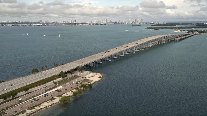 Pan across Rickenbacker Causeway in Miami Florida connecting two urban islands with heavy traffic