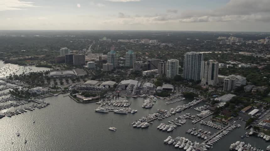 Aerial flyby footage of Dinner Key Marina in Coconut Grove Florida showcasing boats on dock and a beautiful view of the southern Florida coastline