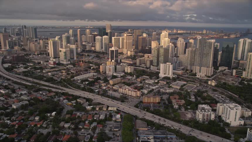 Aerial footage of Downtown Miami at dusk tilting up from SW 3rd Avenue to reveal the city skyline and towering buildings during sunset in Florida