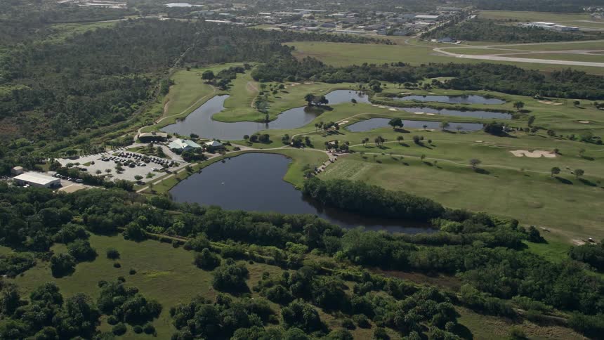 Aerial view of Fairwinds Golf Course in Fort Pierce Florida as the camera approaches and orbits the course