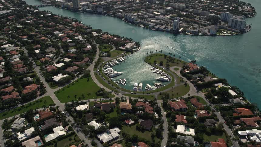 Aerial footage of a small marina surrounded by houses and an island in Bal Harbour Florida