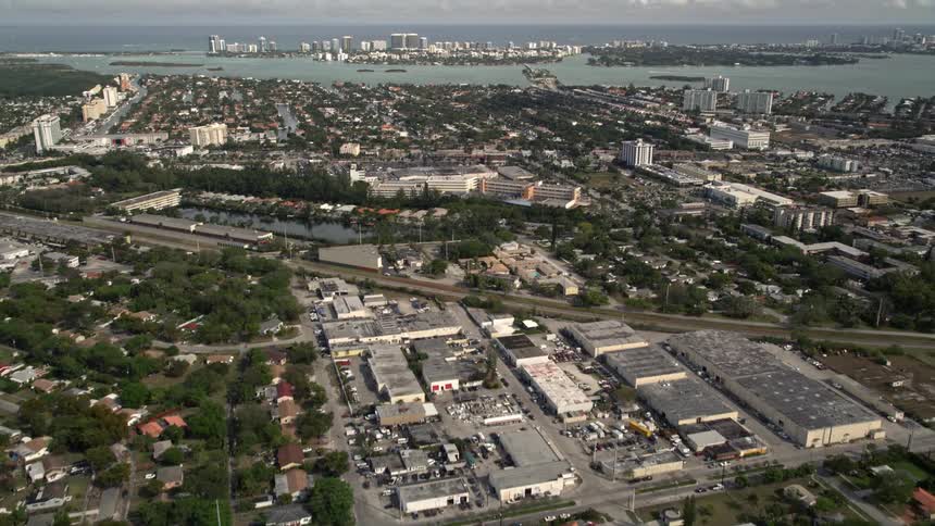 An aerial view of a North Miami suburban neighborhood reveals Bal Harbour Florida while tilting up towards Biscayne Bay