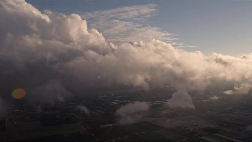 Approaching a beautiful cloud formation at dusk over Miami Florida as the sun sets in the background