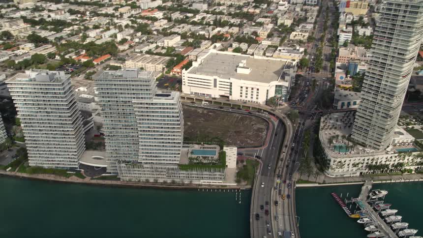 Aerial view of slow traffic and condos on the MacArthur Causeway as it pans over South Beach and the marina in Southern Florida