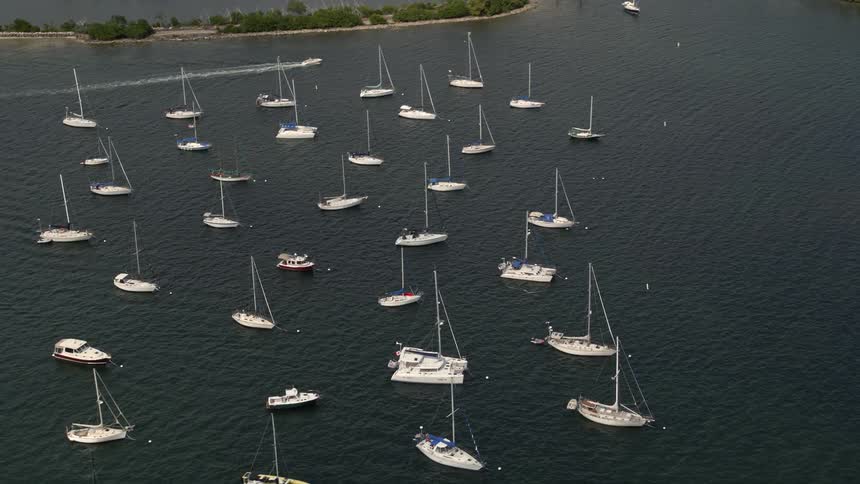 Sailboats are anchored in Dinner Key Marina in Coconut Grove FL in this stunning aerial footage