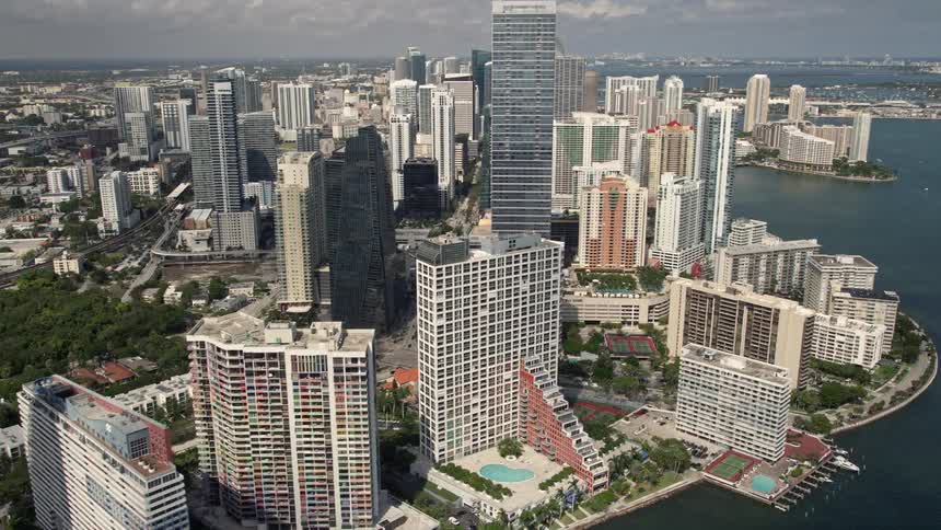 Aerial footage of high-rise condominiums lining the shoreline of Downtown Miami Florida