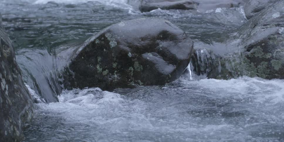 Water rushes over rocks in a river
