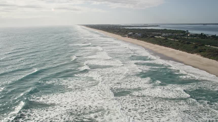 An aerial view of waves crashing onto Melbourne Beach in Florida during the daytime