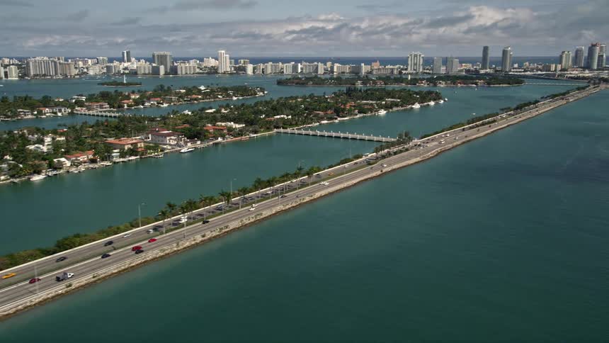 Aerial footage of Palm Island and MacArthur Causeway with light traffic passing through in Miami Florida