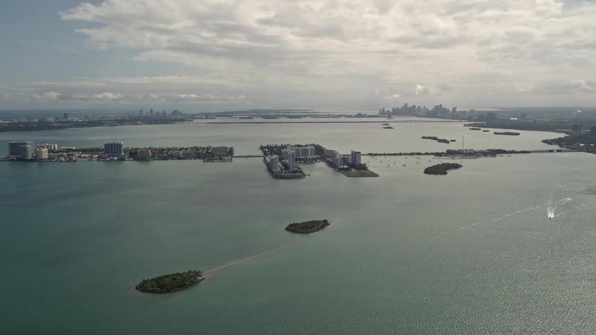 Aerial view of a small island with waterfront homes in Biscayne Bay Florida on a partly cloudy day
