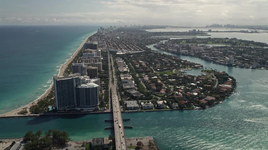 Aerial footage of Bal Harbour Florida tilting up from a coastal road to reveal residential neighborhoods