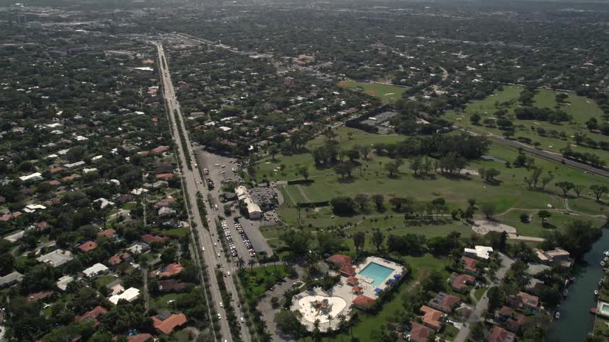 An aerial view of Miami Shores Florida showcasing the scenic canal waterfront suburbs and large freeways as the camera tilts up to reveal the Miami Shores Country Club