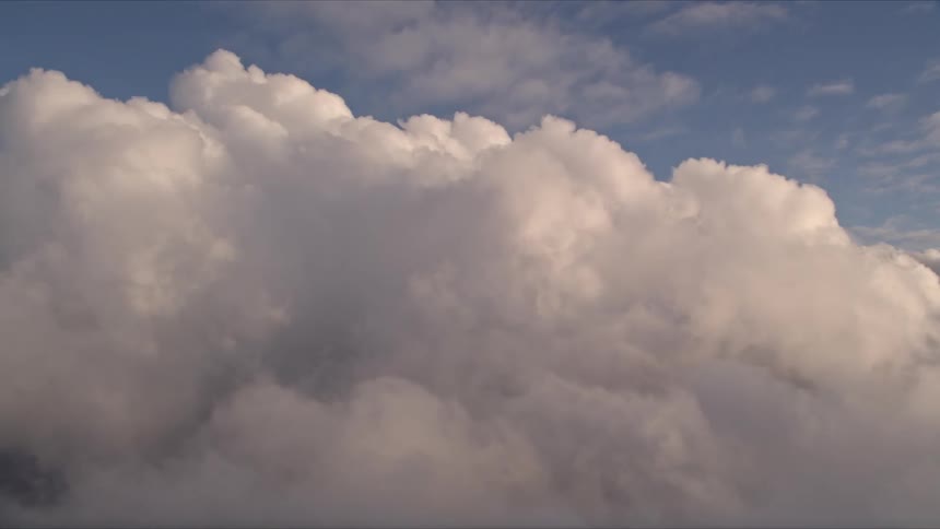A breathtaking aerial view of the sunset over Miami captured with large fluffy white clouds filling the sky