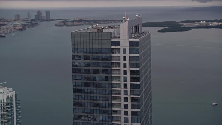 An aerial footage of the Four Seasons Hotel tower at sunset in Downtown Miami Florida showcasing the breathtaking sight of the city skyline behind the skyscraper