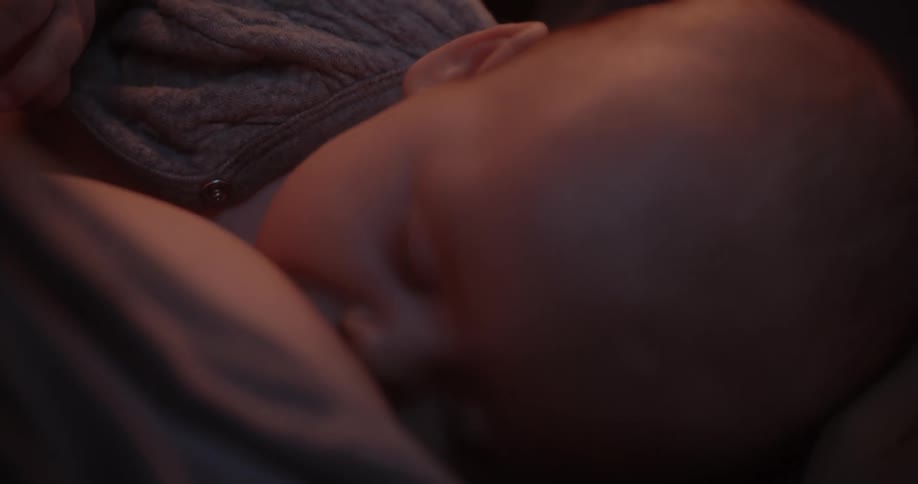 Mother breastfeeds her baby son