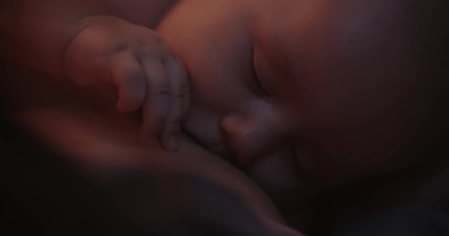 Infant nursing with eyes closed and hand movement
