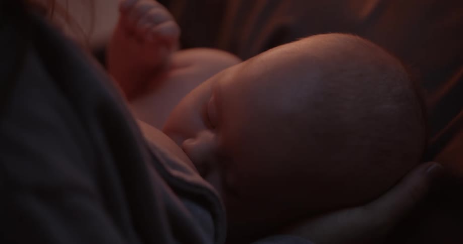 Mother with bangs and shirt breastfeeds baby