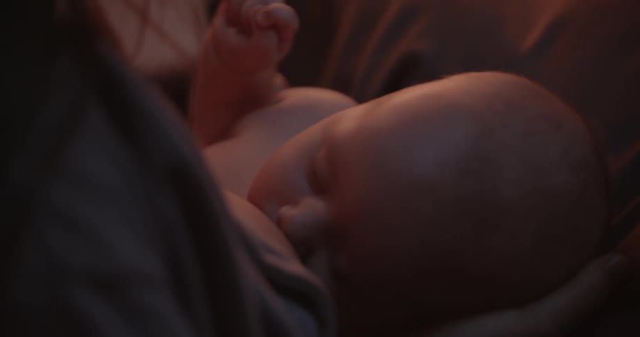 Mother with brown hair breastfeeds baby son