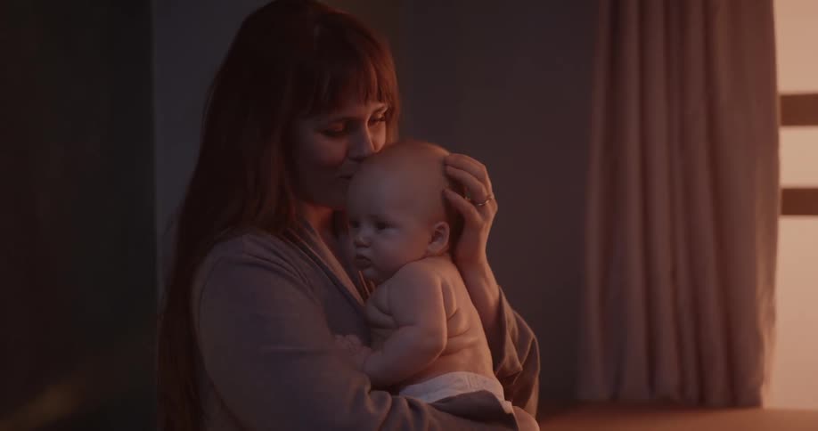 Mother sways and kisses her baby