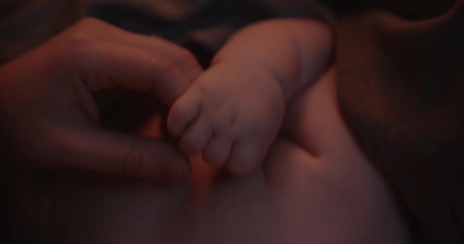 Newborn baby holds mothers finger