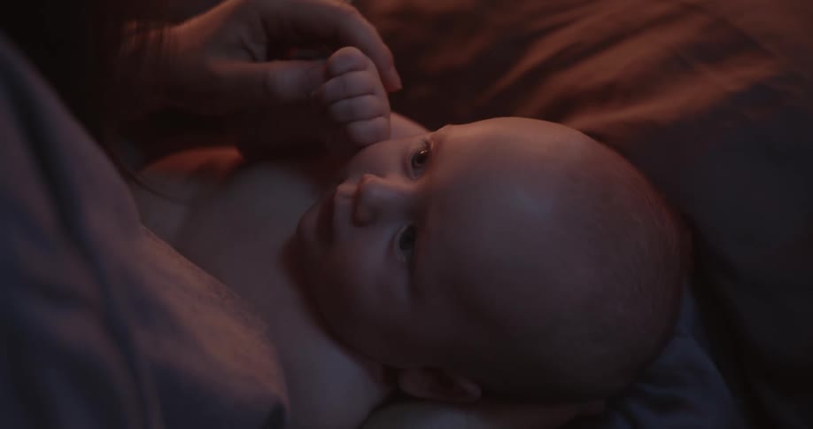 Mother touches arm of child while her baby lies in her lap