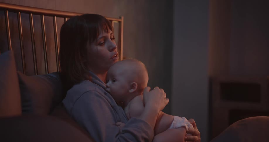 A mother pats her babys back while singing trying to get it to burp