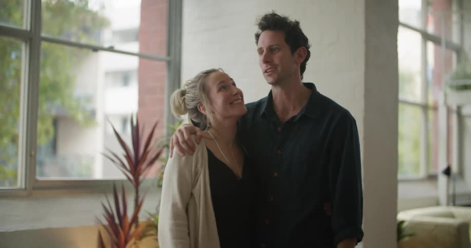 Man and woman are hugging and standing indoors