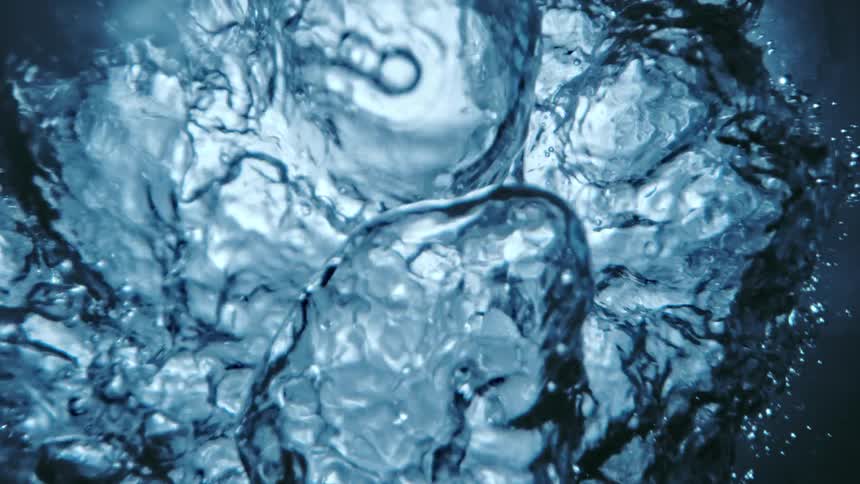 A close up of water with large ripples and splashes on the surface