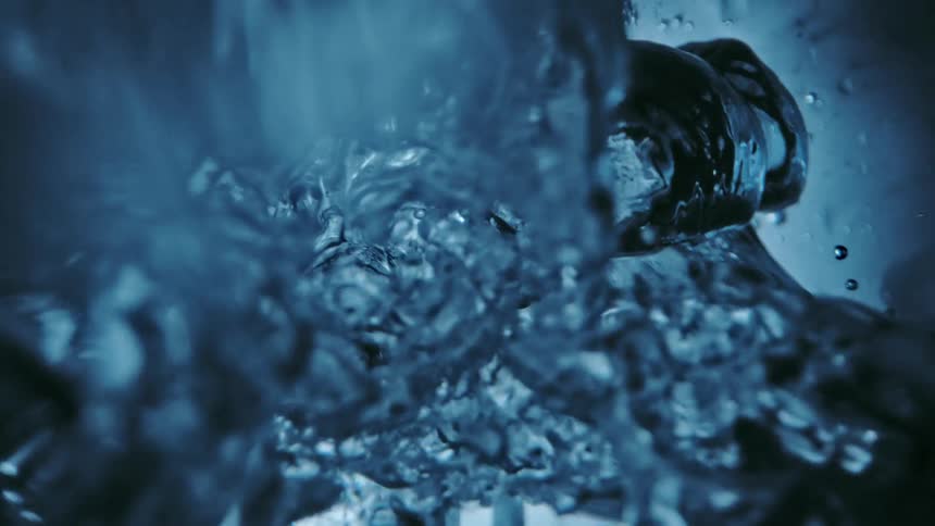 Abstract water and bubbles against a light reflecting light blue and black background