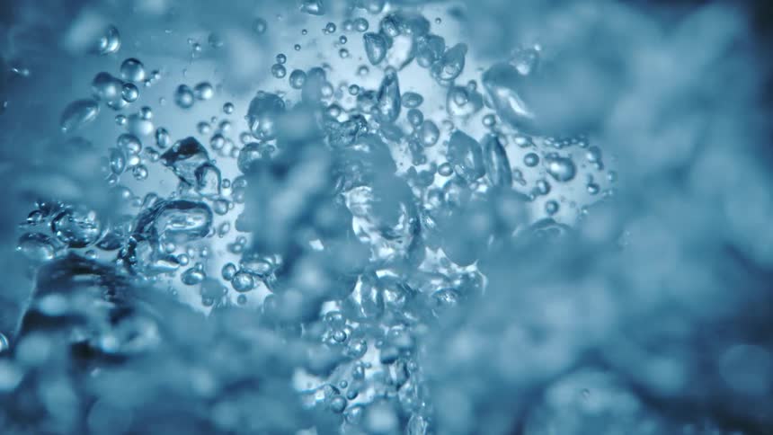 A close up of water droplets under water moving around rapidly