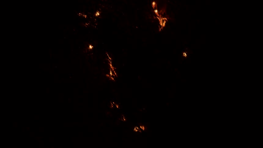 Small orange and yellow lights appear to dance through the darkness