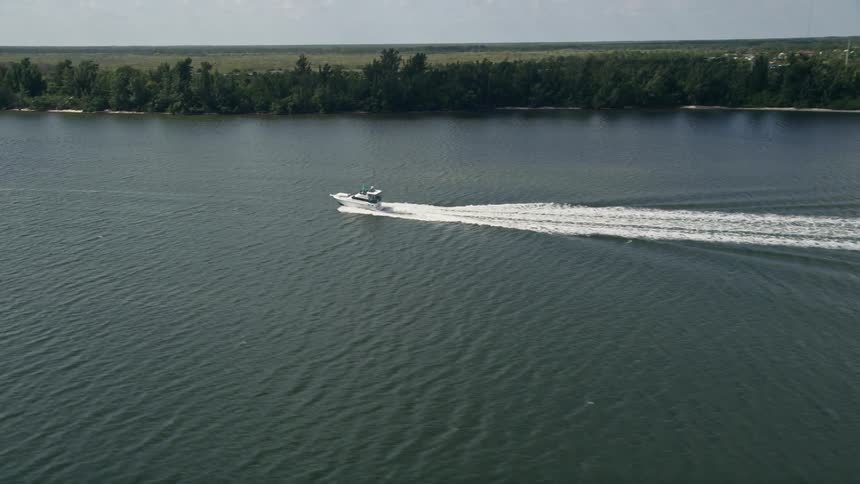 Five K aerial footage of a fishing boat navigating through the Indian River in Hobe Sound Florida