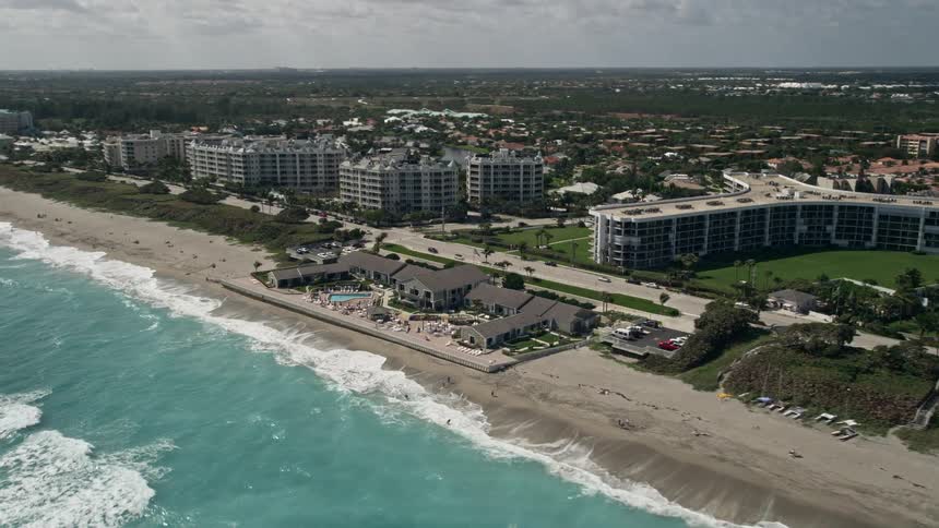 Take in the stunning view of the Jupiter Reef Club resort and beachgoers enjoying a sunny day at the Florida coastline