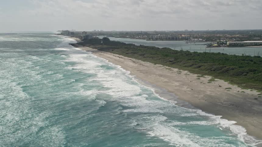 Fly over Tequesta Beach in Florida and capture an empty beach hit by strong waves