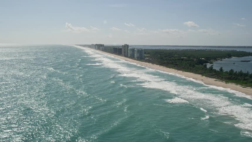 An aerial video of approaching Jensen Beach apartment buildings in Florida while following the shoreline