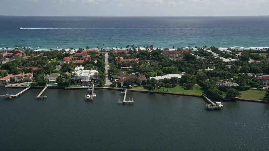 Aerial footage of luxurious lakefront mansions with private docks in Palm Beach Florida