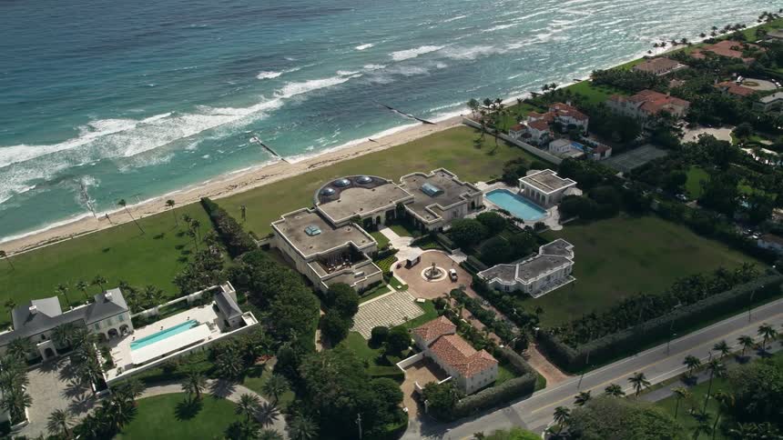 An aerial view of a luxurious mansion by the oceanfront in Palm Beach Florida
